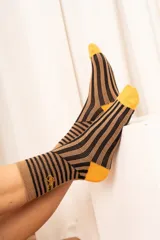 Medias de caña media con estampado de líneas onduladas en tonos beige y negro, talones y punteras en color verde lima y detalle de bordado en el lateral.