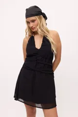 Vestido corto color borgoña, con escote halter, tiras finas y detalle de lazos en la cintura.