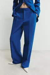 Pantalón de tiro alto con pernera recta, bolsillos laterales y cierre frontal con cremallera, botón y gancho.