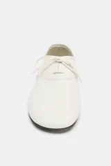 Zapatos planos de piel color blanco, con cierre de cordones en el empeine y detalle de pespuntes decorativos.