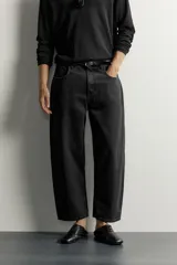 Jeans tapered wide fit de hombre, confeccionados en denim de algodón con efecto lavado en tono azul oscuro. Presentan diseño de cinco bolsillos, tiro medio, corte relajado y cierre frontal con cremallera y botón.