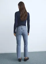 Pantalón de jean estilo flare con tiro medio, diseño crop y bajo deshilachado. Cuenta con cinco bolsillos, cierre de cremallera y botón, y trabillas para cinturón.