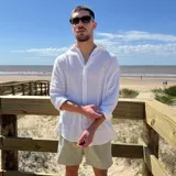 Camisa negra de lino con textura, corte oversize, cuello clásico y mangas largas con puños abotonados.