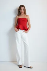 Top rojo sin tirantes, de escote recto y hombros descubiertos, con diseño ajustado en el torso y bajo acabado con peplum. Cierre lateral con cremallera oculta.
