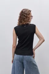 Remera sin mangas de silueta entallada y corte al cuerpo, confeccionada en algodón elastizado con textura acanalada y escote redondo.