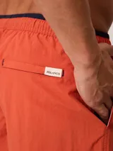 Short de baño Polanco modelo Loraz, color coral, con cintura elástica, cordón ajustable blanco y negro, bolsillos laterales y pequeño logo circular estampado en la pierna.
