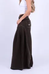 Jean de corte ancho y tiro medio, color marrón chocolate, con costuras a la vista en contraste y diseño de paneles laterales que aportan volumen.