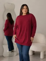 Buzo de hilo gris con cuello redondo, mangas largas y diseño holgado, adornado con aplicaciones de flores en relieve.