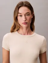 Vestido corto de manga corta confeccionado en tejido jersey de algodón con elastano. Presenta un corte slim ceñido al cuerpo, cuello redondo con detalle de canalé y el monograma de la marca bordado en el pecho.