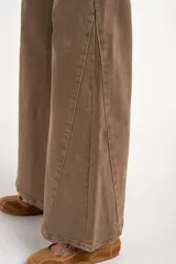 Jean de corte flare y tiro alto, color marrón lavado con costuras decorativas verticales en las piernas y diseño de cinco bolsillos.