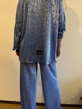 Camisa plisada color celeste con brillo, de corte holgado y manga larga con puños elásticos.