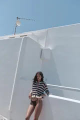 Chaqueta de punto calado con cuello redondo, manga larga y diseño a rayas horizontales en tonos blanco, azul y bordó. Cuenta con cierre frontal de botones y terminaciones en rib.