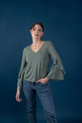 Blusa gris melange de punto tejido fino, con escote en V y mangas largas anchas terminadas en volados.