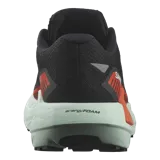 Championes de trail running Salomon DRX Defy Grvl, color negro con detalles en naranja y entresuela verde menta, diseñados con soporte y ligereza para correr en caminos de grava y asfalto.