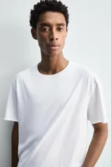 Camiseta de corte relajado confeccionada en algodón ligero, con cuello redondo y mangas cortas con bordes de acabado irregular.