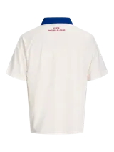 Camiseta de manga corta con cuello tipo polo en color azul, cuerpo en color blanco y calce relajado. Presenta estampados frontales con la leyenda 'FIFA WORLD CUP' y 'CAN MEX USA', junto con un parche conmemorativo del evento.