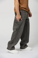 Jean baggy de corte amplio, estilo carpintero, color gris oscuro con efecto acid wash y costuras en contraste.
