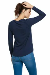 Remera de manga larga color beige, con cuello redondo y estampado frontal con efecto foil metalizado y texto.