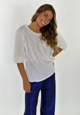 Blusa negra de manga 3/4 con cuerpo de algodón liso y mangas abullonadas de tejido transparente y arrugado.