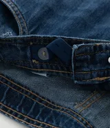 Pantalón de jean modelo wide leg, de tiro medio y corte amplio desde la cadera hasta el ruedo. Presenta cierre frontal con botón, bolsillos laterales y traseros, y trabillas en la cintura.