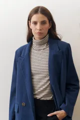 Rompeviento color beige con rayas horizontales finas en marrón, cuello alto y mangas largas.