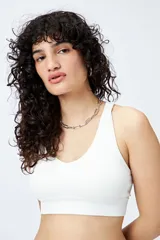 Top deportivo blanco de diseño seamless con escote en V y breteles anchos.