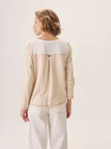 Remera de manga larga con diseño de paneles combinados, presentando un frente de lino y mangas y espalda de viscosa con elastano. Posee cuello redondo y costuras visibles con detalle de hilo en contraste en el ruedo.