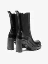 Bota Chelsea negra de cuero con tacón alto y suela gruesa dentada. Presenta un protector de puntera Oval D en poliuretano termoplástico.