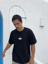 Remera negra de corte boxy con parche bordado en el pecho.