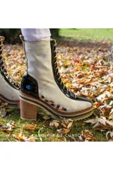 Botas borcegos de cuero blanco con detalles en cuero charol negro y dorado, cordones frontales, plataforma, taco ancho de madera y diseño pintado a mano.