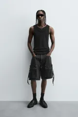 Bermuda de corte relajado en denim de algodón color beige, estilo cargo, con cinco bolsillos y bolsillos plastrón con solapa en las perneras.