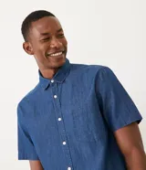 Camisa de manga corta confeccionada en algodón, con cuello camisero, cierre frontal abotonado y un bolsillo en el pecho.