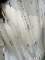 Campera bomber de corte holgado con cierre frontal, confeccionada en tela con estampado gráfico de pelotas de fútbol y redes en tonos verdes, rosados y ocres.