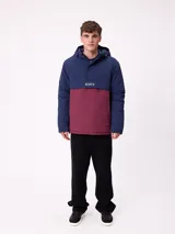 Campera tipo canguro con capucha, diseño color block en azul marino y bordó. Cuenta con cierre frontal parcial, bolsillos laterales y logo de la marca bordado en el pecho.