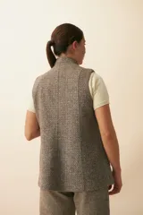 Chaleco color crema con solapas, corte entallado y bolsillos plaqué.