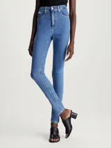 Jeans ajustados de mezclilla elástica, tiro alto, pierna estrecha y lavado azul medio. Presentan diseño de cinco bolsillos y bragueta con cremallera.