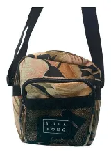 Morral Billabong modelo Pass By con estampado tropical de hojas en tonos verde, beige y rosado, con correa ajustable negra y bolsillo frontal de red con etiqueta de la marca.