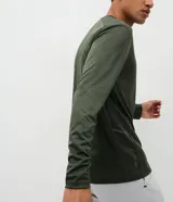 Remera deportiva de manga larga con cuello redondo, confeccionada en tejido técnico Dry Fit. Presenta un diseño liso con sutiles detalles reflectantes en los hombros.