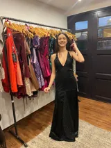 Vestido largo sin mangas con escote en V halter y aberturas laterales (cut-outs) en la cintura. El cuerpo superior presenta un llamativo diseño estampado multicolor, mientras que la falda larga es de tejido texturizado brillante en color verde esmeralda con inserciones godet en el ruedo.