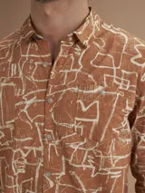 Camisa de manga larga color ladrillo con estampado abstracto en blanco.