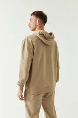 Buzo de felpa negro con capucha, cordones ajustables y bolsillo tipo canguro. Tiene puños y cintura acanalados, y logo en grifa de plástico.