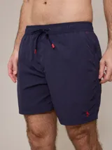 Short de baño azul marino con cintura elástica ajustable con cordón y logo de la marca bordado en rojo en la pierna izquierda.