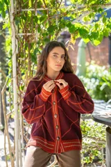 Saco tejido de punto con diseño geométrico de rombos en color azul y blanco. Presenta cuello redondo, cierre frontal con botones, mangas largas abullonadas y terminaciones acanaladas en puños y ruedo.