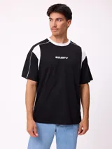 Remera de corte holgado en color negro con detalles en blanco en el cuello y paneles laterales. Presenta logo de la marca estampado en el centro del pecho.