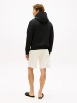 Buzo con capucha y cordón ajustable Tommy Hilfiger, color negro, confeccionado en felpa de puro algodón. Cuenta con bolsillo tipo canguro y logo impreso en el pecho en tono dorado.
