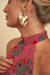 Aros tipo caravanas dorados, de diseño abstracto y voluminoso con textura opaca.