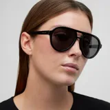 Lentes de sol estilo aviador con montura robusta de color negro y doble puente. Presentan lentes polarizadas oscuras con protección UV400.
