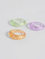 Set de tres anillos de resina transparente con diseño labrado, en colores verde, naranja y lila.