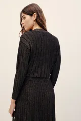 Cardigan cruzado de punto con hilo metalizado, color negro, de manga larga y escote en V profundo.
