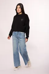 Pantalón de jean estilo wide leg con tiro alto, diseño de costuras diagonales en el frente y ruedo deshilachado.